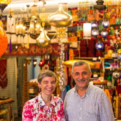 Christina und Necati in ihrem Laden, umgeben von vielen bunten Lampen und Textilien