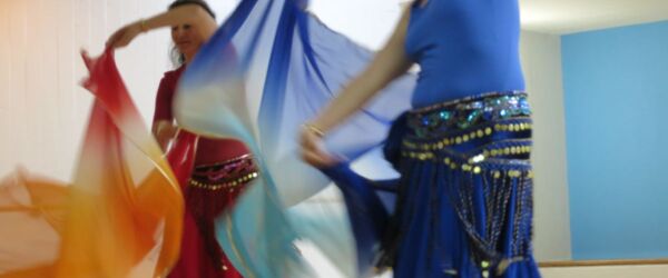 zwei Tänzerinnen mit Schleiern in Rot und Blau
